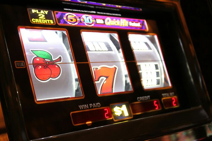 Slot machine screen showing a winning combination with a dollar bet and credit display in a casino setting.