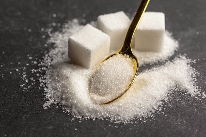 Close-up of sugar cubes and granulated sugar on a spoon illustrating bad things people face in life.