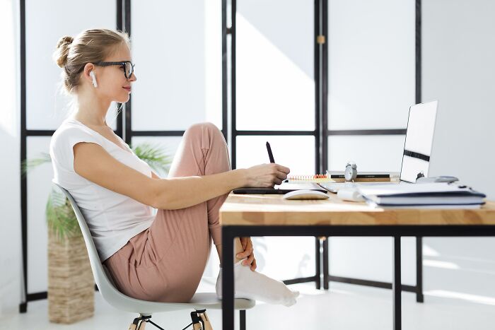 Woman working at a desk with laptop and writing tablet, reflecting on the bad things people face in life.