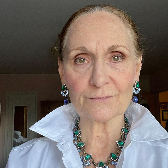 Older woman with green and blue gemstone earrings and necklace, wearing a white collared shirt, unrecognizable 37 years later. Older woman with green and blue gemstone earrings and necklace, wearing a white collared shirt, unrecognizable 37 years later.