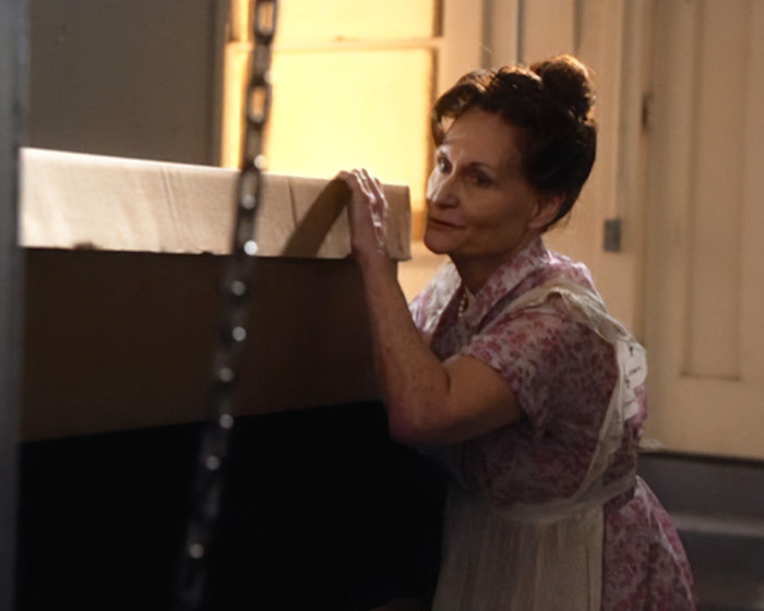 Beloved ’90s star and Tom Cruise’s Rain Man co-star wearing floral dress and apron, leaning on a table indoors. Beloved ’90s star and Tom Cruise’s Rain Man co-star wearing floral dress and apron, leaning on a table indoors.