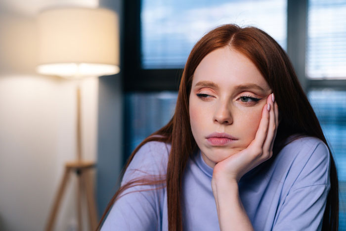 Young woman looking sad and thoughtful indoors, illustrating a friendship of 10 years on the rocks and feelings of betrayal. Young woman looking sad and thoughtful indoors, illustrating a friendship of 10 years on the rocks and feelings of betrayal.