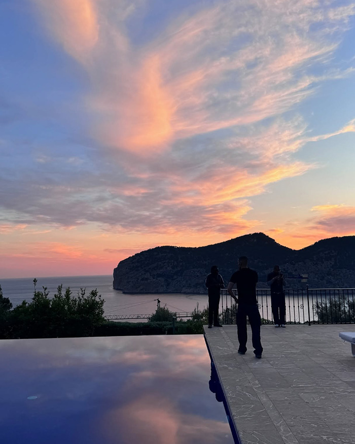 Sunset over coastal cliffs with three people standing near infinity pool, fans fear grooming related to Bianca Censori sister topic. Sunset over coastal cliffs with three people standing near infinity pool, fans fear grooming related to Bianca Censori sister topic.