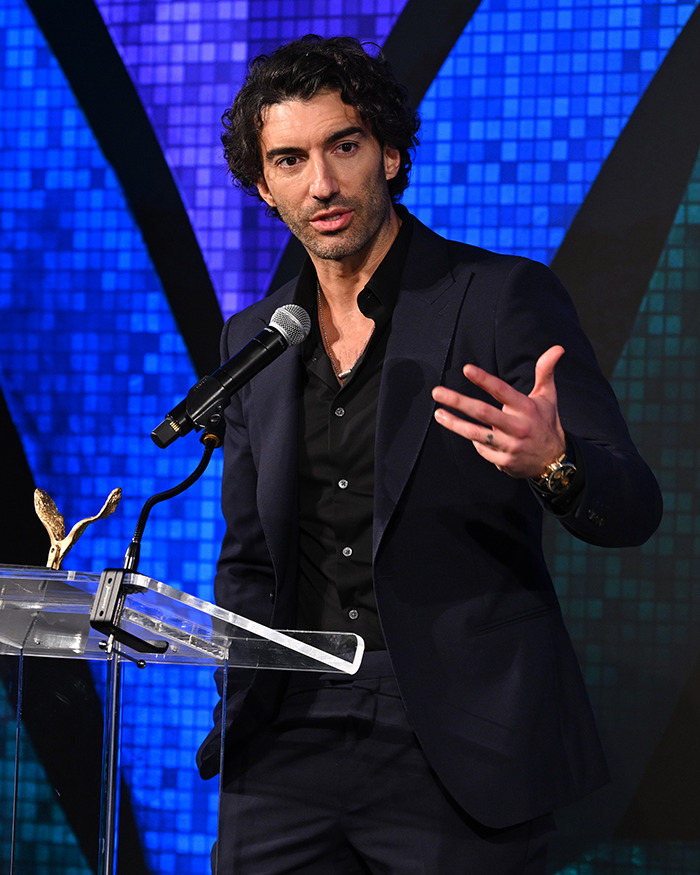 Man in dark suit speaking at a podium with microphone, related to Blake Lively lawsuit against Justin Baldoni news. Man in dark suit speaking at a podium with microphone, related to Blake Lively lawsuit against Justin Baldoni news.