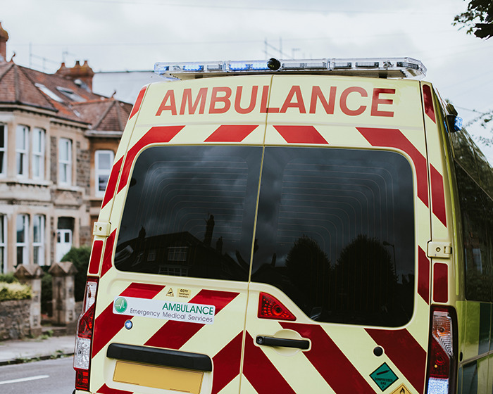 Rear view of an ambulance parked on a residential street responding to an emergency involving a viral scarf challenge incident. Rear view of an ambulance parked on a residential street responding to an emergency involving a viral scarf challenge incident.