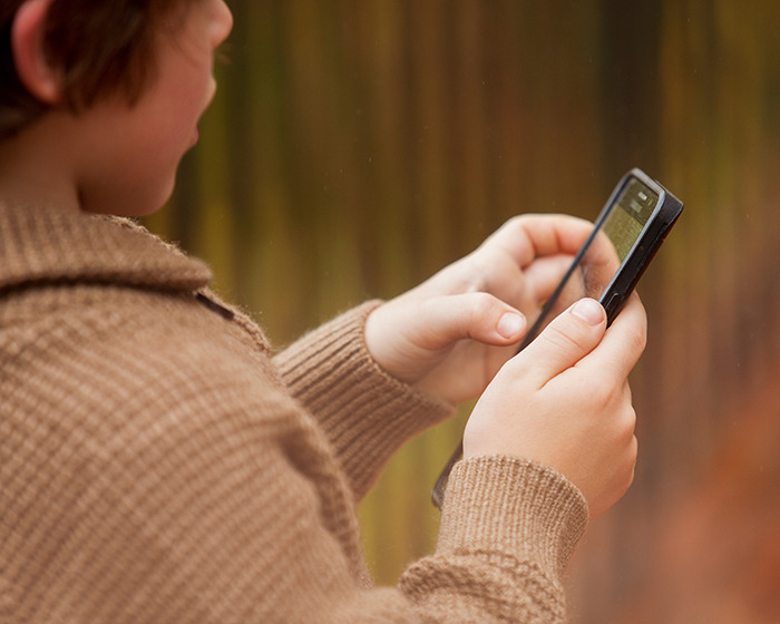 Boy aged 12 using a mobile phone outdoors, illustrating the viral scarf challenge and its tragic consequences. Boy aged 12 using a mobile phone outdoors, illustrating the viral scarf challenge and its tragic consequences.