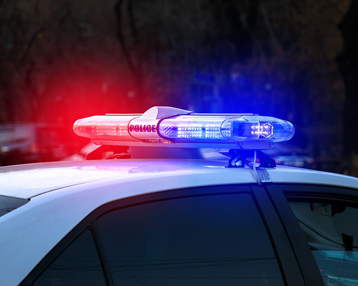 Police car with flashing red and blue lights responding to an incident involving a boy in a viral scarf challenge. Police car with flashing red and blue lights responding to an incident involving a boy in a viral scarf challenge.