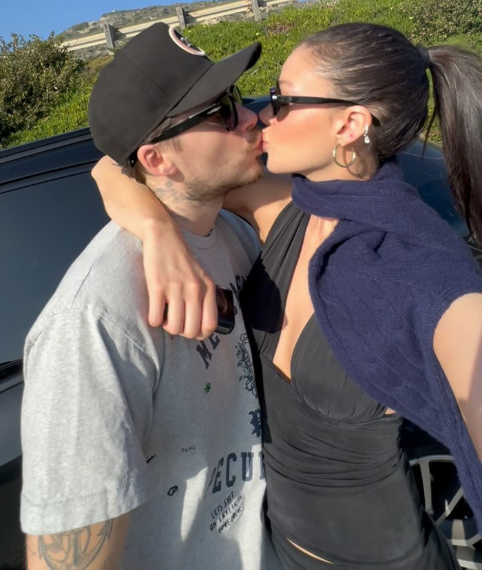 Brooklyn Beckham kissing woman outdoors, wearing sunglasses and casual clothing amid alleged no contact feud with David and Victoria Beckham. Brooklyn Beckham kissing woman outdoors, wearing sunglasses and casual clothing amid alleged no contact feud with David and Victoria Beckham.