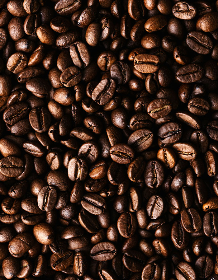 Close-up of dark roasted coffee beans, highlighting caffeine as the main focus related to excessive consumption risks. Close-up of dark roasted coffee beans, highlighting caffeine as the main focus related to excessive consumption risks.
