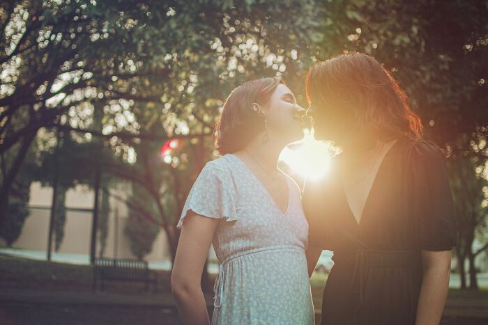 Two women in a park expressing love and connection, highlighting a relationship where one partner struggles emotionally.