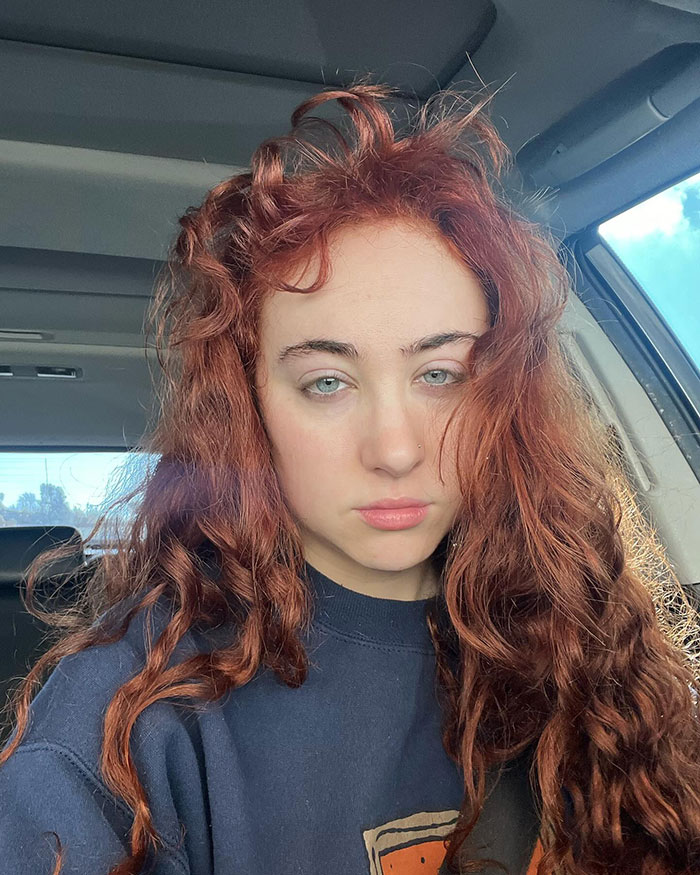 Chappell Roan with long curly red hair, wearing a dark sweatshirt, showing off her healthy body in natural light. Chappell Roan with long curly red hair, wearing a dark sweatshirt, showing off her healthy body in natural light.