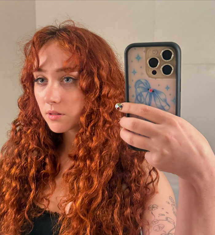 Chappell Roan with long curly red hair taking a selfie, showing off her healthy body and natural look. Chappell Roan with long curly red hair taking a selfie, showing off her healthy body and natural look.