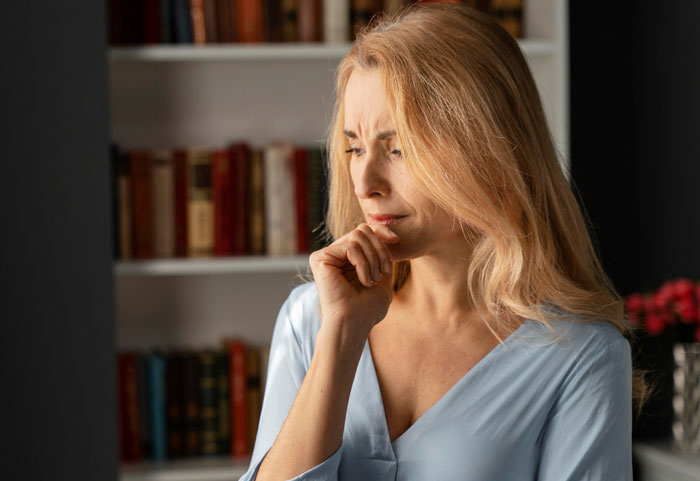 Pensive woman in a blue blouse, contemplating relationship doubts amid an 8-year affair and disbelief from others. Pensive woman in a blue blouse, contemplating relationship doubts amid an 8-year affair and disbelief from others.
