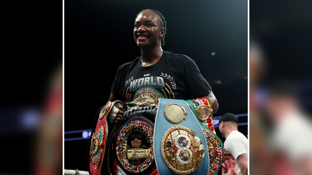 Claressa Shields smiling in boxing ring wearing championship belts showcasing her net worth and boxing success in 2025.