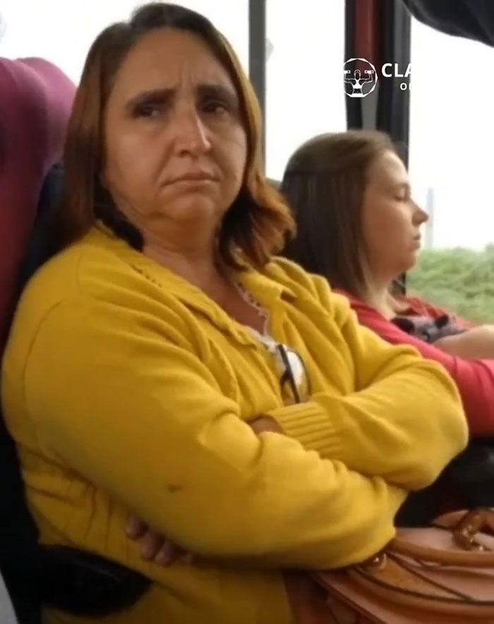 Woman sitting with arms crossed on a bus, appearing serious, before transformation into bodybuilding champion. Woman sitting with arms crossed on a bus, appearing serious, before transformation into bodybuilding champion.