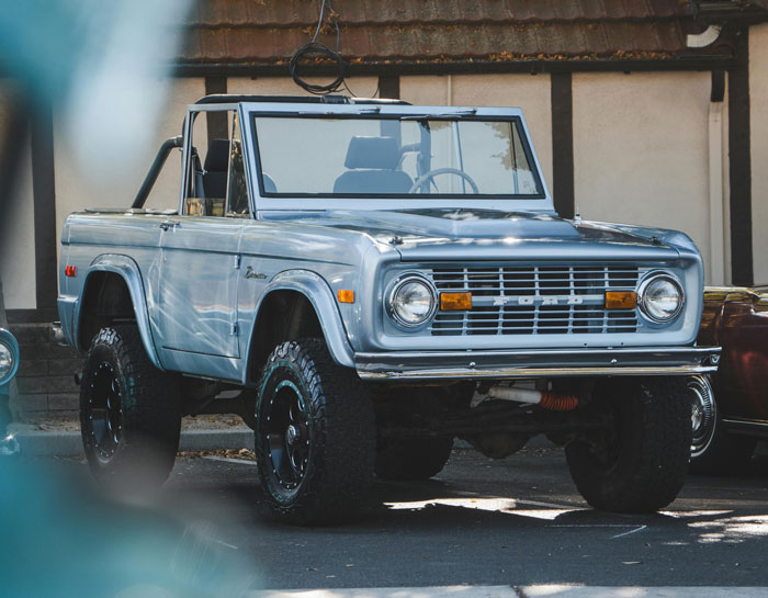 Vintage 1972 Ford Bronco parked outdoors, showcasing classic design and rugged off-road tires in natural light. Vintage 1972 Ford Bronco parked outdoors, showcasing classic design and rugged off-road tires in natural light.