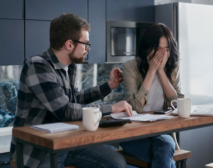 Man comforts distressed woman in kitchen, reflecting tension after buying 1972 Ford Bronco while wife is postpartum. Man comforts distressed woman in kitchen, reflecting tension after buying 1972 Ford Bronco while wife is postpartum.