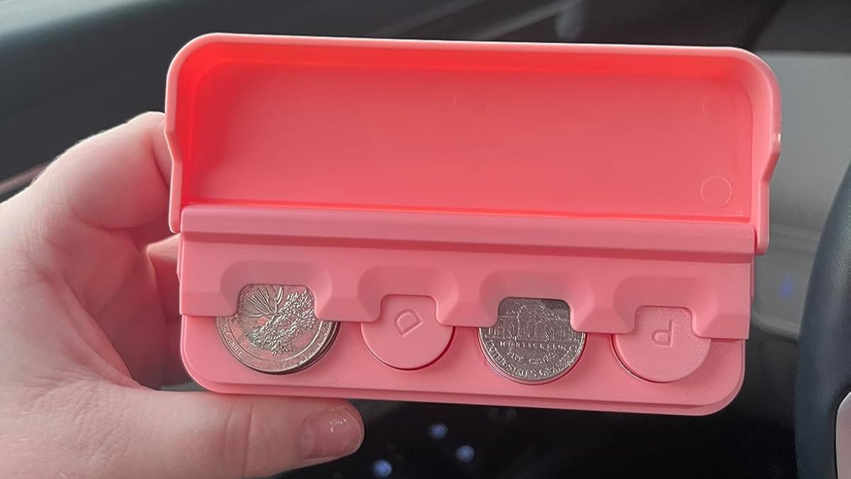 Hand holding a pink coin organizer designed for car use, showcasing a clever car find for the commute.