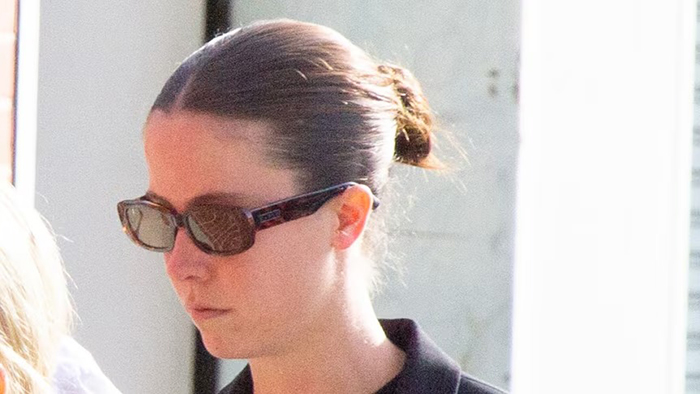 Woman wearing sunglasses and black top, walking outside, related to case of setting male friend on fire over misogynistic comment. Woman wearing sunglasses and black top, walking outside, related to case of setting male friend on fire over misogynistic comment.