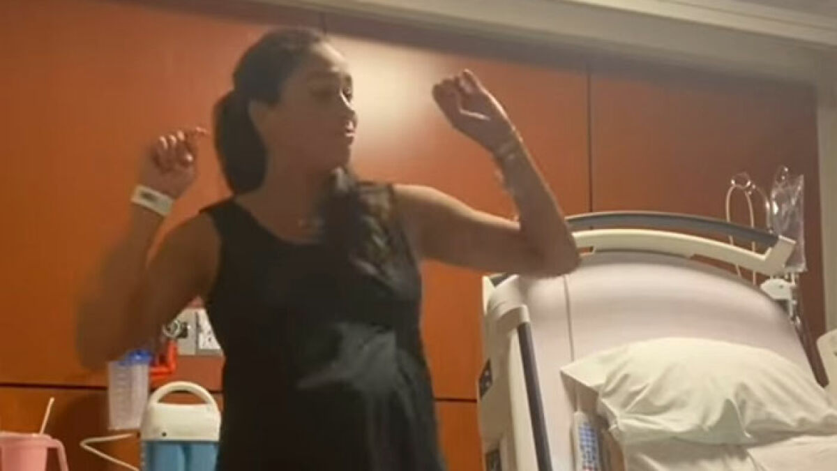 Pregnant woman dancing in a hospital room, highlighting Meghan Markle's viral pregnancy twerk video mastermind plan.