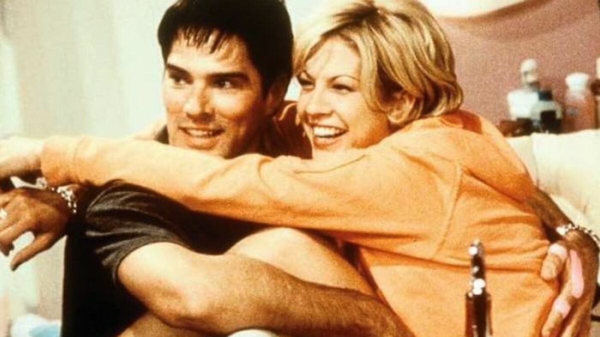 Famous 90s actress and co-star smiling and embracing in a casual scene showcasing youthful look and charm.