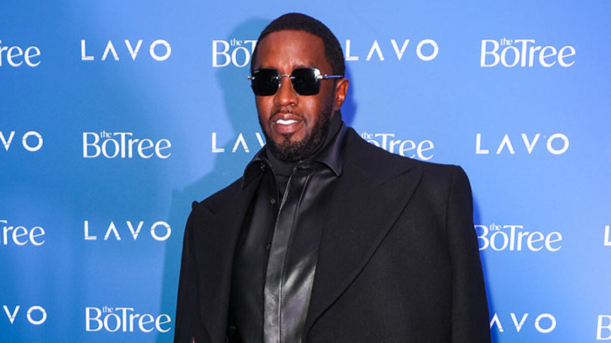Diddy wearing sunglasses and a black outfit at a blue event backdrop, linked to woman revealing his aged look in court.