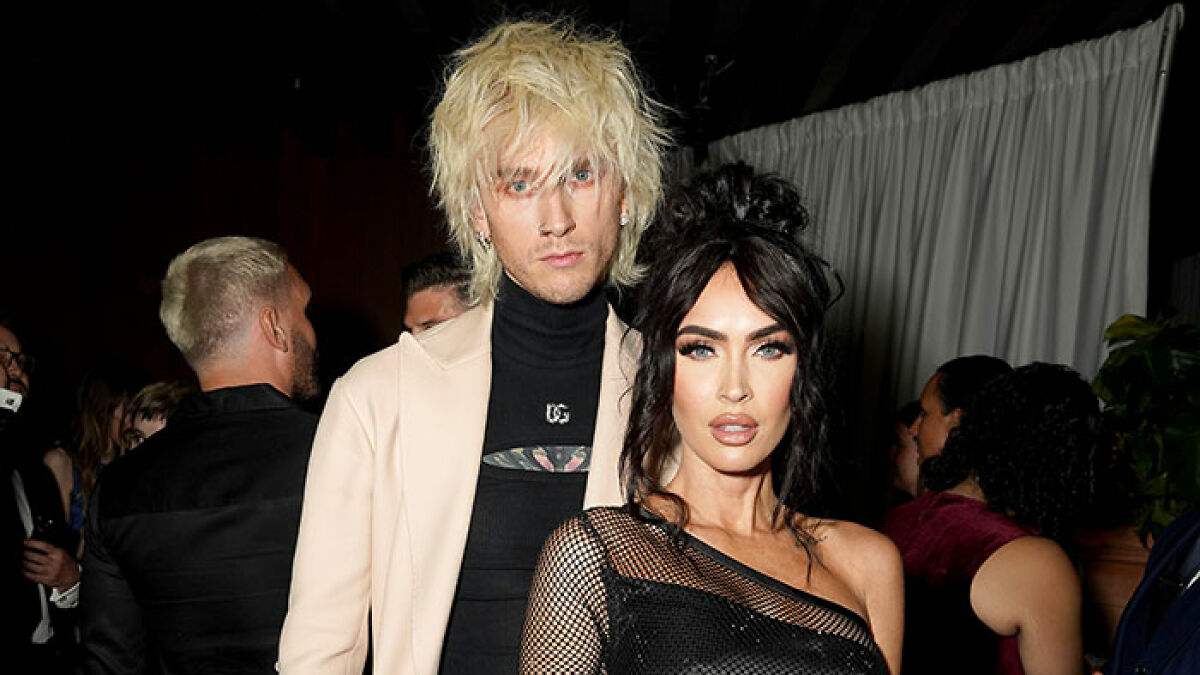 Megan Fox and Machine Gun Kelly posing together at an event, highlighting their baby's unique name reveal.