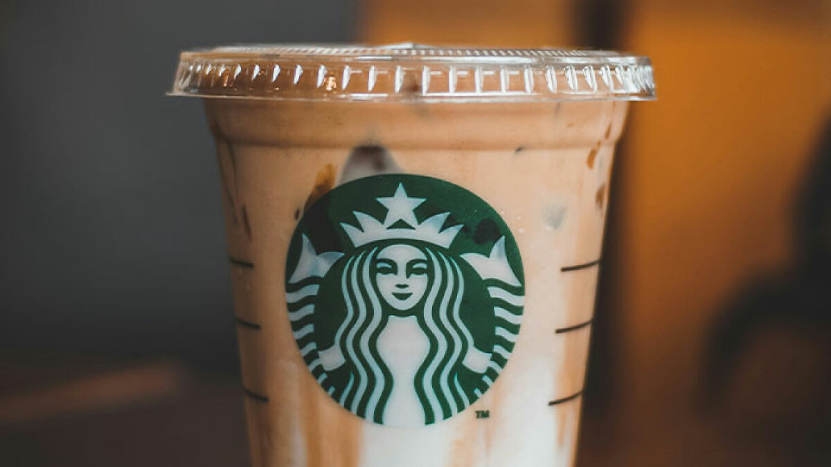 Starbucks iced coffee cup with logo, representing viral video of barista shutting down customeru2019s 5-cent hack.