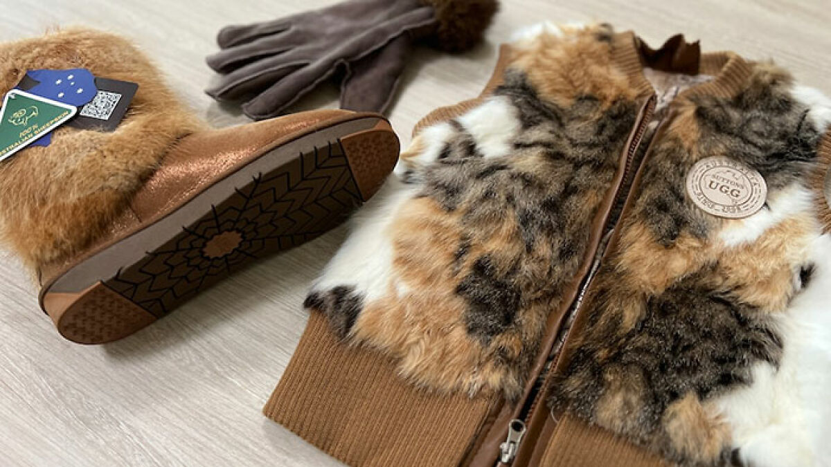 Fur vest and boots laid out on floor highlighting mass fury over fashion brand using cat fur instead of wool.
