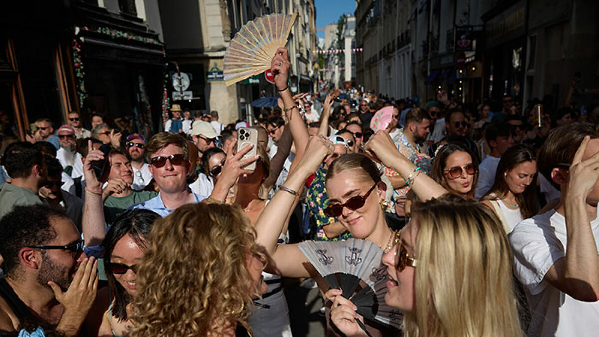 Crowd of festival attendees enjoying music outdoors on a sunny day, highlighting violence against women concerns.
