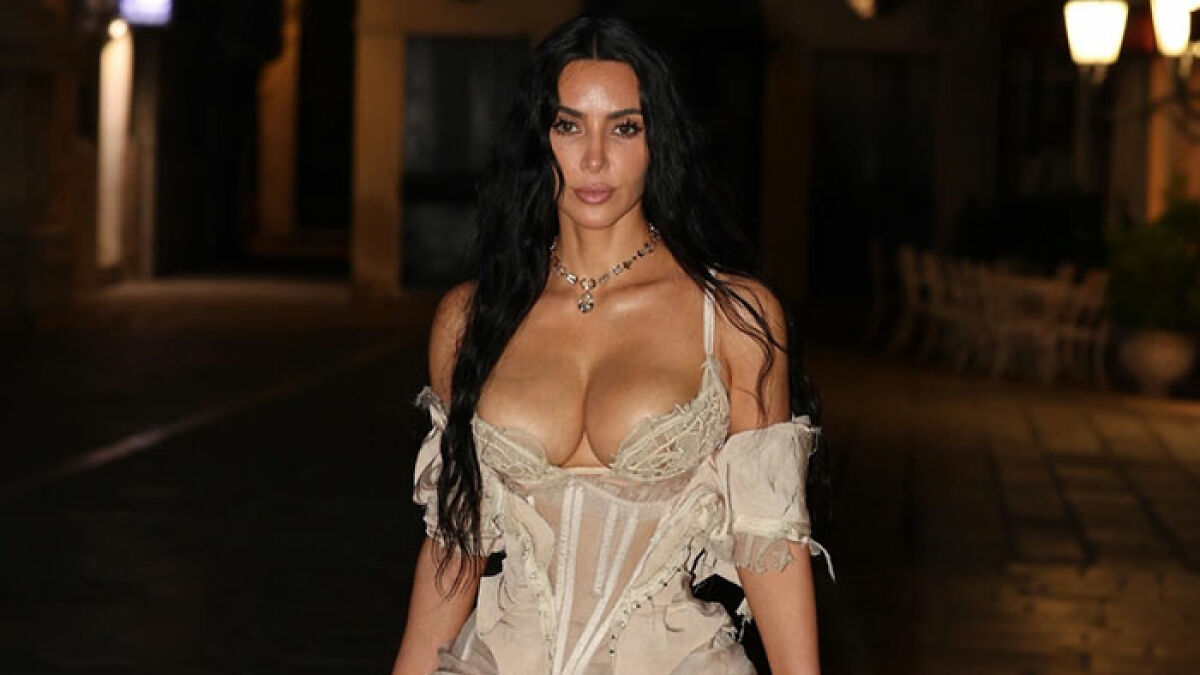 Woman posing in a racy revealing look at a pajama-themed afterparty with dim outdoor lighting in the background.