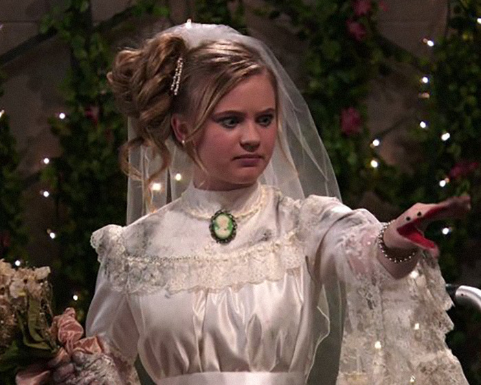 Young woman in vintage wedding dress with veil and glove puppet, highlighting child star's unrecognizable transformation and Disney concerns. Young woman in vintage wedding dress with veil and glove puppet, highlighting child star's unrecognizable transformation and Disney concerns.