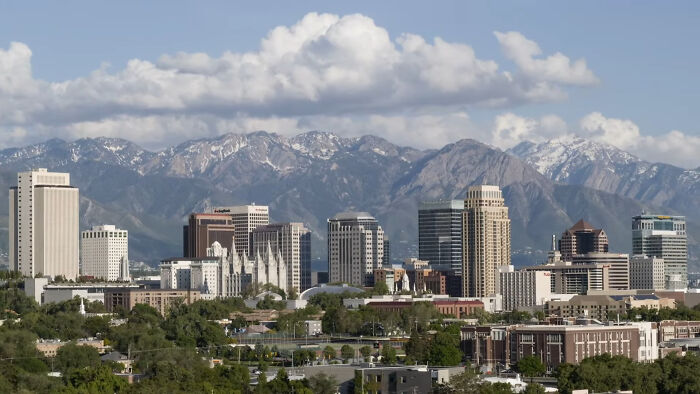 City skyline with towering buildings set against a backdrop of mountains, representing creepy and chilling spots in the U.S.