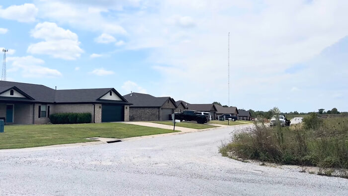 Quiet suburban street with houses and overgrown grass, one of the creepy and chilling spots in the U.S.