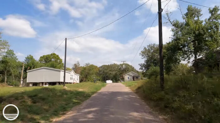 Rural road with mobile homes and trees in a creepy and chilling spot in the U.S. that visitors say never again.