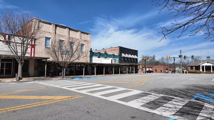 Empty street in a small town with old buildings under a blue sky, one of the creepy and chilling spots in the U.S.