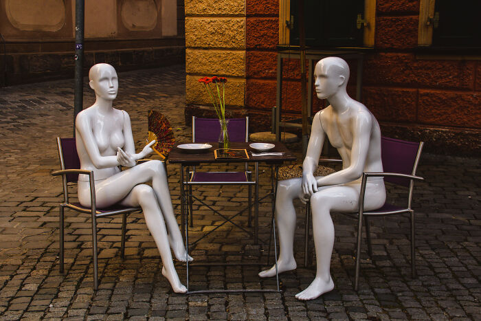 Two white mannequins seated at a small table outdoors, evoking eerie and creepy spots in the U.S.