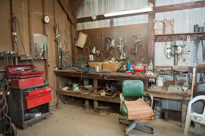 Abandoned workshop with old tools, dusty workbench, and worn-out chair in a creepy and chilling spot in the U.S.