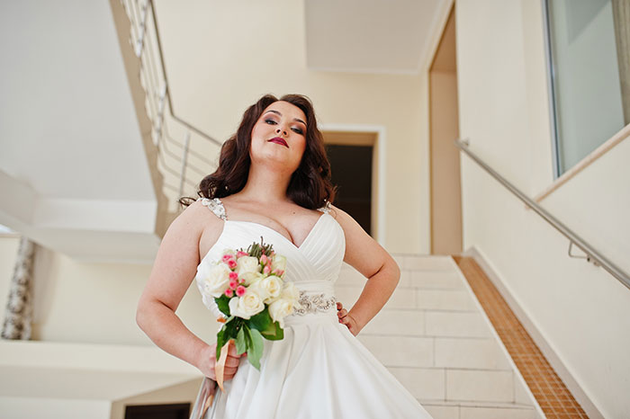 Woman in wedding dress holding bouquet, standing on stairs, symbolizing health concerns and wedding photo aesthetic conflict. Woman in wedding dress holding bouquet, standing on stairs, symbolizing health concerns and wedding photo aesthetic conflict.