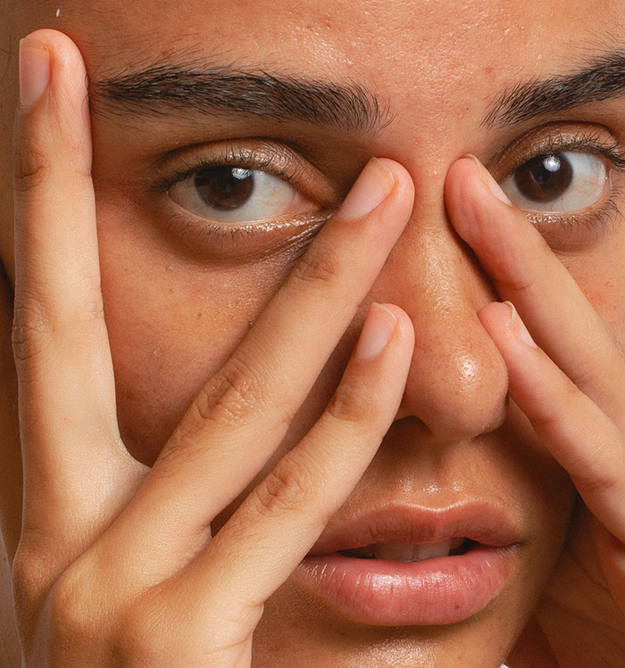 Close-up of woman touching her face, expressing concern about refusing to risk health for sister’s wedding photo aesthetic. Close-up of woman touching her face, expressing concern about refusing to risk health for sister’s wedding photo aesthetic.
