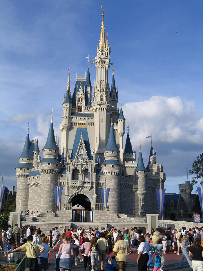 Crowds gather in front of Disney castle as a woman complains about being scolded by Disney staff for inappropriate outfit. Crowds gather in front of Disney castle as a woman complains about being scolded by Disney staff for inappropriate outfit.