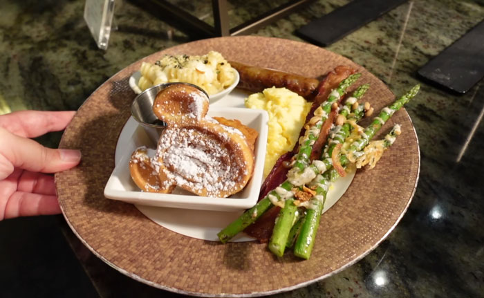 Breakfast plate at Disneyland featuring Mickey-shaped waffles, asparagus, sausage, scrambled eggs, and macaroni salad. Breakfast plate at Disneyland featuring Mickey-shaped waffles, asparagus, sausage, scrambled eggs, and macaroni salad.