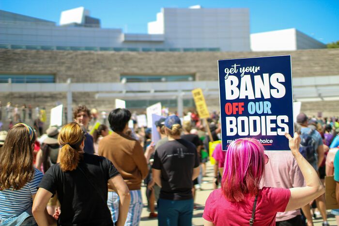 Crowd at a protest with signs, highlighting people share most privileged things said about bodily rights.