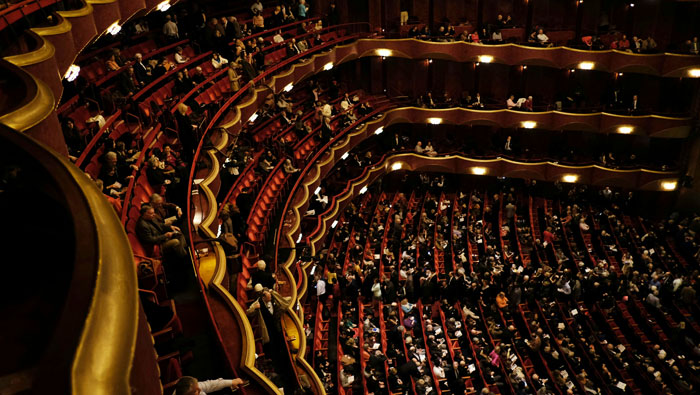 Theater audience seated in red chairs watching a performance as drama and narcissist behavior unfolds backstage. Theater audience seated in red chairs watching a performance as drama and narcissist behavior unfolds backstage.