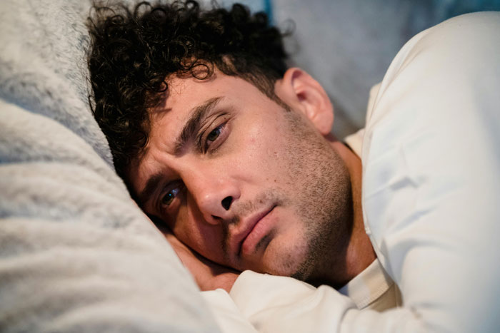 Man lying on bed looking sad and contemplative after discovering girlfriend’s squad secretly hates him. Man lying on bed looking sad and contemplative after discovering girlfriend’s squad secretly hates him.
