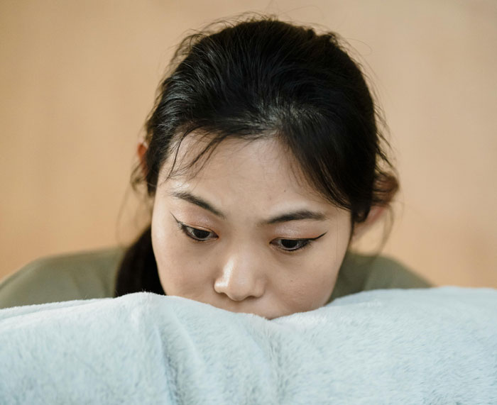 Mother of ring bearer looking shocked and upset, sitting alone with a worried expression indoors. Mother of ring bearer looking shocked and upset, sitting alone with a worried expression indoors.