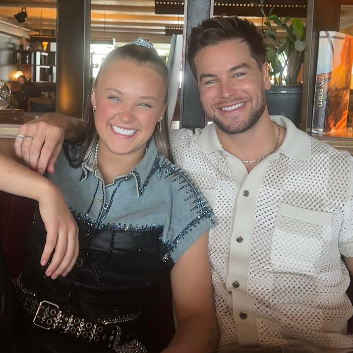 A smiling couple sitting together in a restaurant, illustrating the trend of famous lesbians getting boyfriends this year. A smiling couple sitting together in a restaurant, illustrating the trend of famous lesbians getting boyfriends this year.