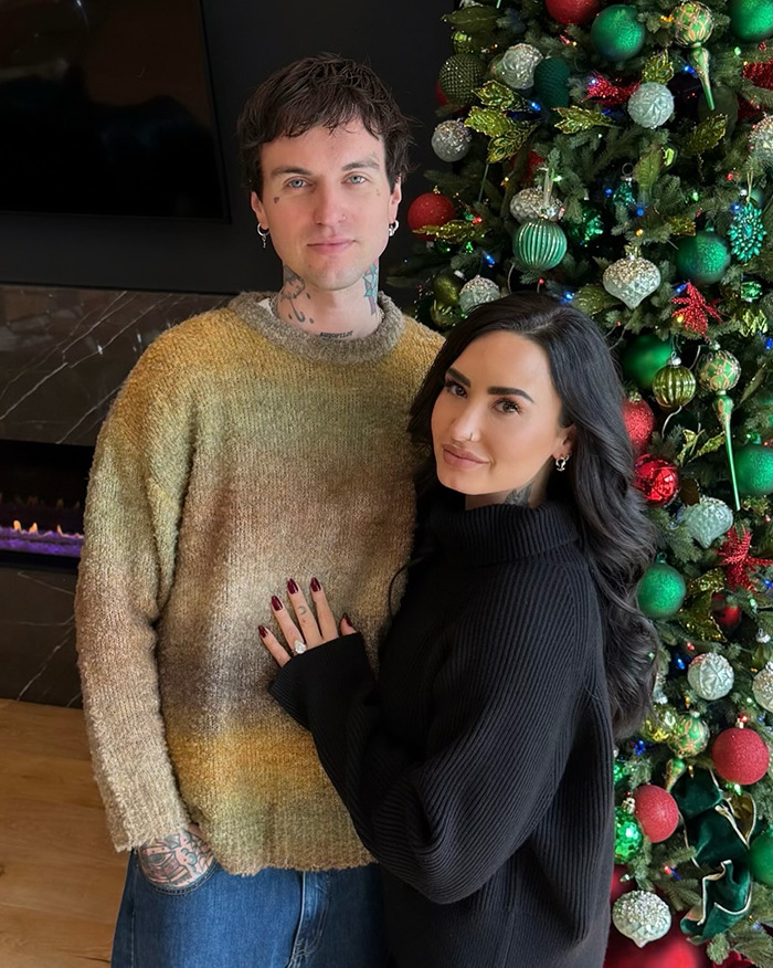 Couple posing by a decorated Christmas tree, highlighting famous lesbians who have gotten boyfriends in 2024 trend. Couple posing by a decorated Christmas tree, highlighting famous lesbians who have gotten boyfriends in 2024 trend.