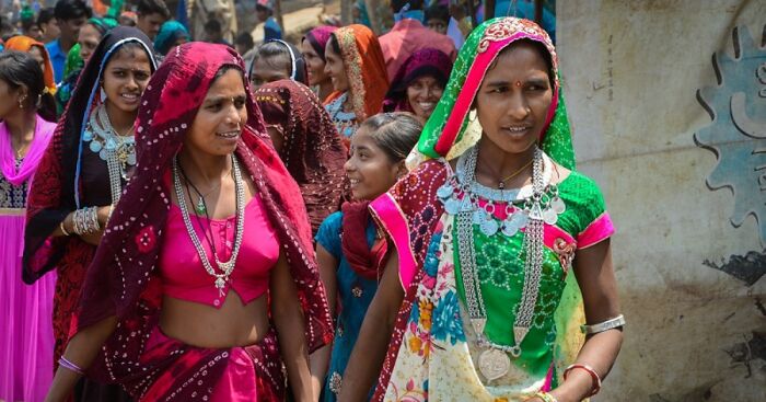 Group of women in colorful traditional attire enjoying a vibrant cultural festival, embodying feel good holidays with spiritual solace.
