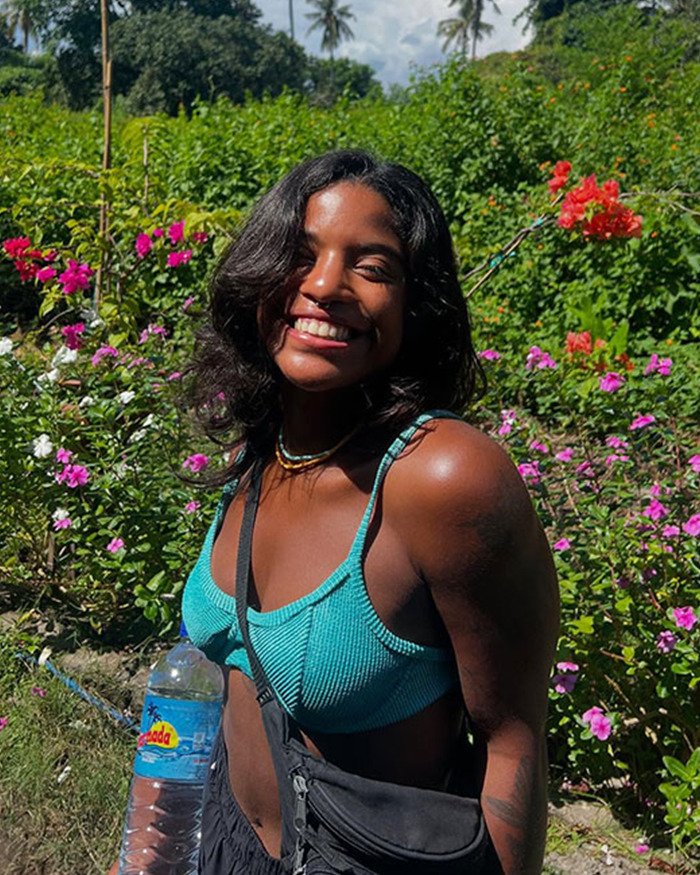 Young tourist smiling outdoors surrounded by vibrant flowers, highlighting a tragic volcanic incident involving a trapped tourist. Young tourist smiling outdoors surrounded by vibrant flowers, highlighting a tragic volcanic incident involving a trapped tourist.